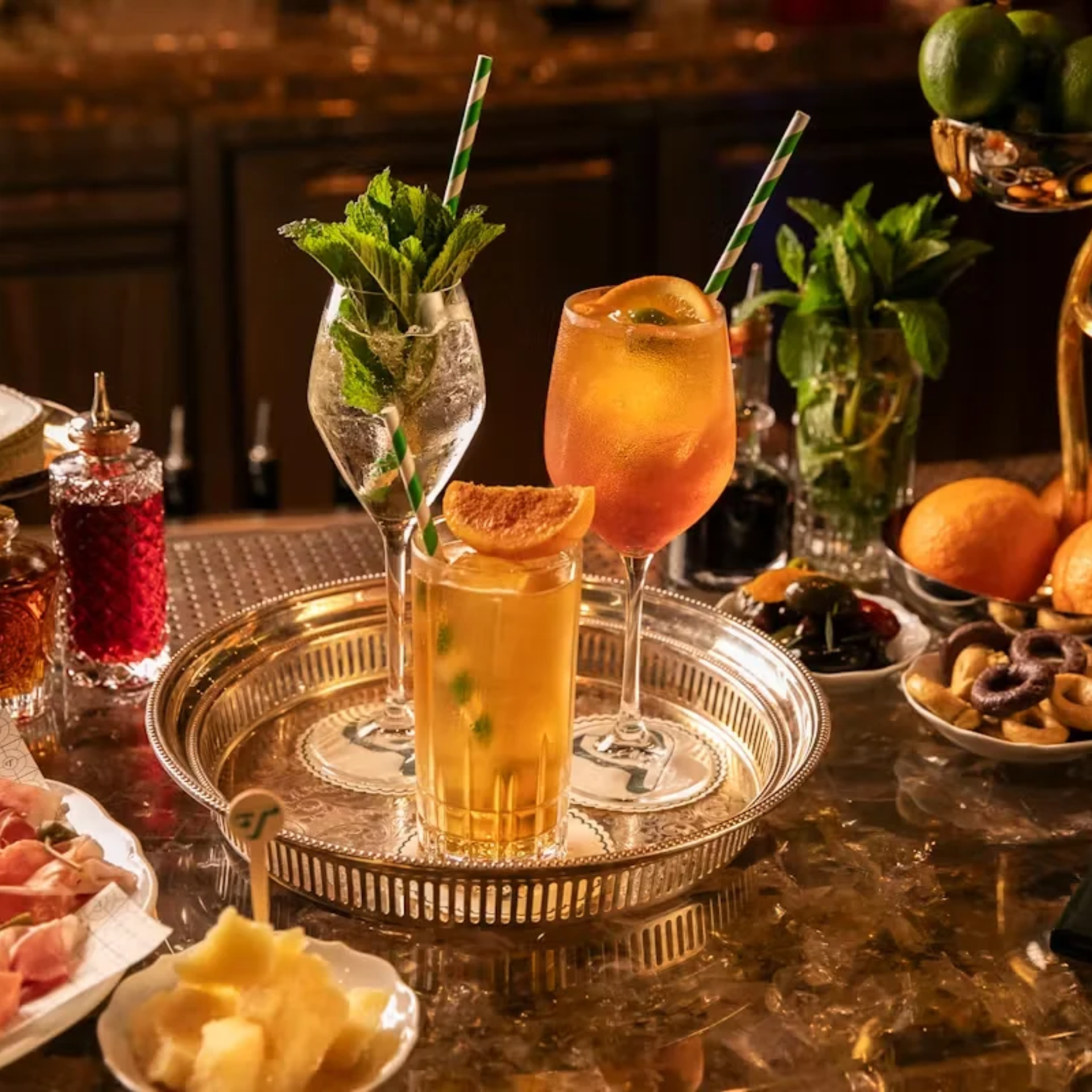 Tray with three cocktails and assorted bar snacks